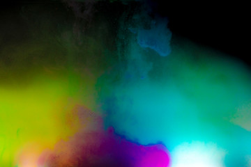 Abstract art powder paint on black background. Movement abstract frozen dust explosion multicolored on black background.