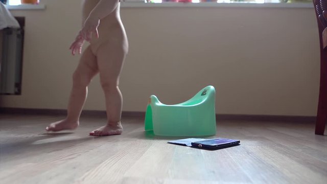 a little girl is sitting on a potty and playing with her phone. viewing cartoons. learning how to work with gadgets. conceptuality with modern-day technology, healthy digestion, housebreaking