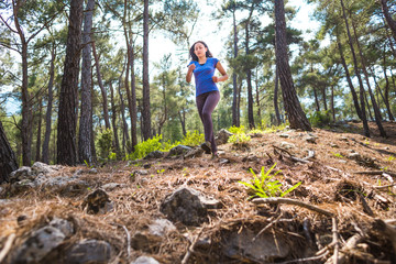 Naklejka na ściany i meble A woman runs along a mountain trail.