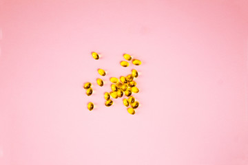 Vitamin d capsules on a pink background. Close up top view