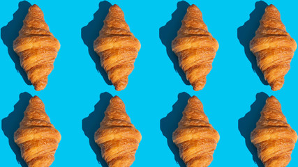 Bakery products pattern with baked croissant. Blue background, top view. Pop art style. Delicious and food concept.