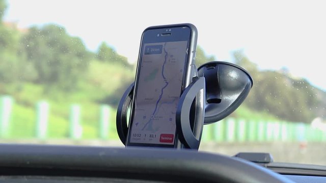 Phone GPS Navigating on Car Dashboard While Driving on a Sunny Day