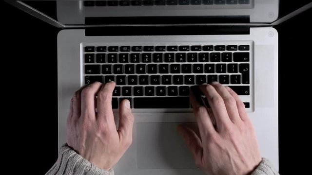 A man working on a laptop online from his home. Top down view.