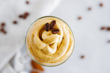Top view close-up on a glass of cold coffee dalgon drink decorated with grains. Copy space