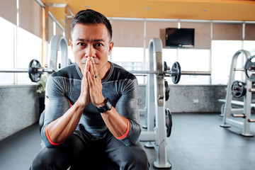 Serious gym owner with pain in his eyes praying for ending of the pandemic and opening gyms and...