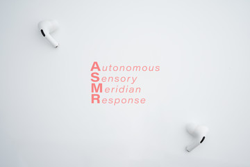 Autonomous sensory meridian response, ASMR text. Earphones to hear sound waves as a symbol of enjoying sounds, whisper or music.