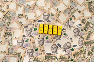 stacks of gold bars on ukraine moneu uah . top view