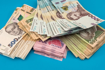 Ukrainian hryvnia money new bills 1000 and 500 isolated on blue. Stack of money.