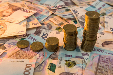 Close up coin stacked growing as financial  chart lying on ukraine money as background. For business growth