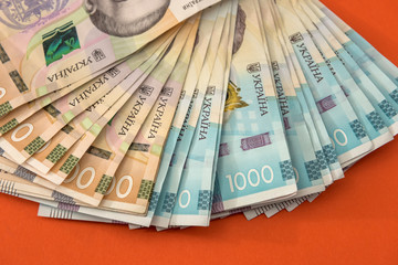 lot of ukraine money, 1000 and 500 new banknotes isolated on red. Hryvnia UAH