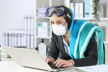 Executive with mask booking vacation on laptop at office