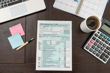 Finance tax form with calculator, laptop and pen. Sticker need help