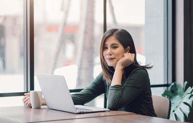 Beautiful Asian Woman Using Laptop Computer Online Working from Home ,  E-Learning , Online Shopping , E-Commerce , Freelance Concept - Healthcare and Social Distancing Concept