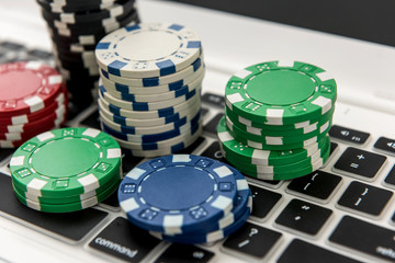 Different of cost casino chips stacking on a laptop. Gabmling