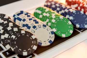 Different of cost casino chips stacking on a laptop. Gabmling