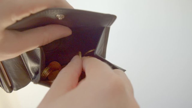 Looking for euro coins in leather wallet.