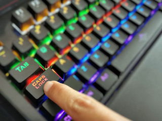 CAPS LOCK button on backlit keyboard with copy space on the right side.  Selective focus at the...