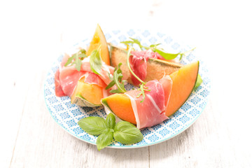 melon slices with prosciutto ham and basil
