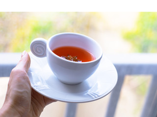 A girl is bringing a cup of tea in the morning