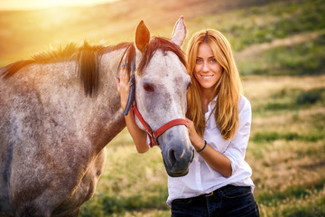 Obraz premium Cute woman hold a horse in nature .