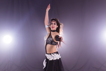 Belly dancer. Young attractive woman dancing tribal fusion on the stage. Oriental exotic dance.