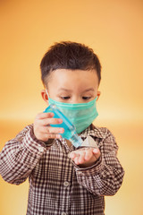 Asian kid use medical mask or surgical mask to protect her from virus, sickness, Covit-19 and coronavirus infection.hand sanitizer in public crowded place.