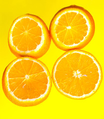 Orange slices on a yellow background close-up