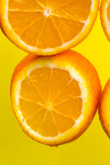 Orange slices on a yellow background close-up