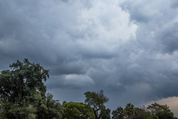 Obraz premium Heavy and dark thunderstorm clouds gather over a residential suburb in the Highveld region of South Africa