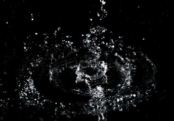 Obraz premium Splashes and drops of water are on a black background.