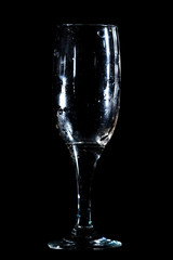 A glass of water is isolated on a black .