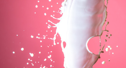 Splashing milk on a pink background.