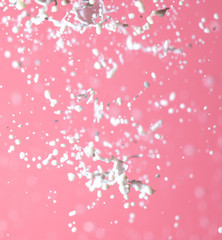 Splashing milk on a pink background.