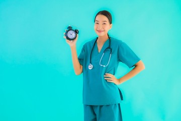 Portriat beautiful young asian doctor woman show clock or alarm