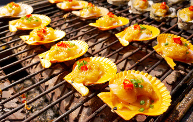 Shellfish in the shells is fried on a barbecue.