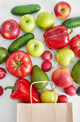 Paper bag with different vegetables isolated on white background.