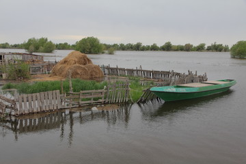  High water near the village of Big Mogoy (hay, boat, fence). Every year in the Astrakhan region,...
