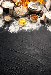 Baking ingredients on black background with copy space