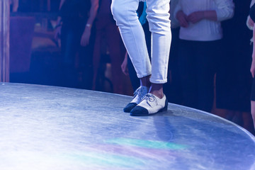 Dancing shoes feet and legs of male ballroom and latin salsa dancer dance teacher on the stage. Social dance, bachata solo and kizomba concept - obrazy, fototapety, plakaty