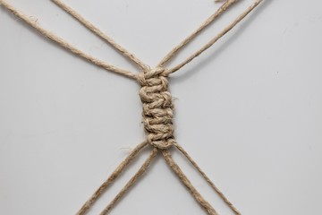 A fragment of a macrame product - joining threads with square kn