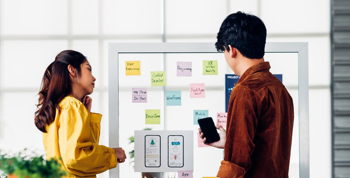 ux developer and ui designer presenting  and testing mobile app interface design on whiteboard in meeting at modern office.Creative digital development mobile app agency
