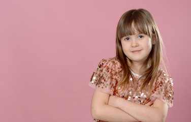 Close up shot of beautiful blonde Caucasian little girl wearing sequin dress