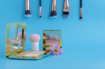 premium makeup brushes, palette eye shadow makeup and blush pads on a bright blue background,...