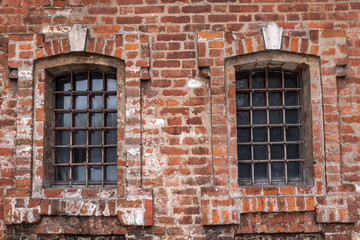 Windows with bars on brick wall