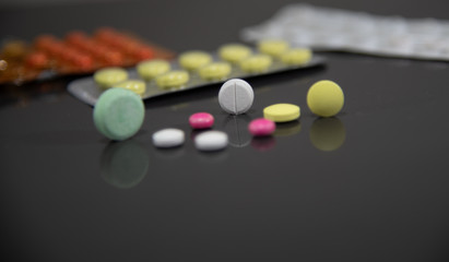 Pills and medicines on a dark mirrored background
