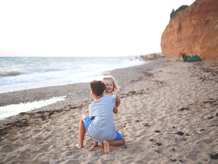 little girl hugs brother on the beach by the sea