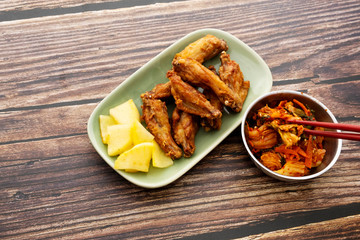 Fried chicken wings with Korean pickle kimchi on a wooden table