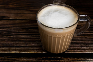 Hot latte coffee on the wooden table surface