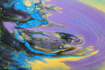 art photography of abstract marbleized effect background. Black, blue, gold, yellow and purple creative colors. Beautiful paint