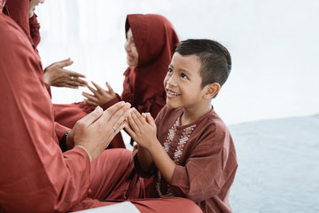 Asian children prostrate and shake hands to apologize while celebrating Eid Ul-Fitr